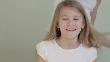 Bir kız, kız kardeşini evde tarıyor.