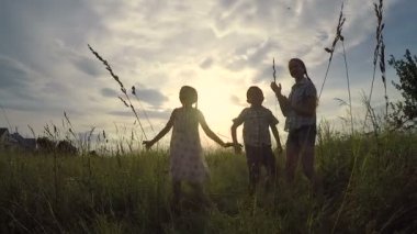Mutlu çocuklar gün batımında parkta oynuyorlar. İnsanlar dışarıda eğleniyor. Arkadaş canlısı aile kavramı.