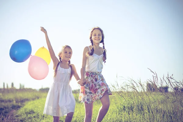 快乐的孩子们白天在田里玩耍 他们在公园的路上走着 手里拿着气球 孩子们玩大自然的乐趣 幸福的概念 — 图库照片