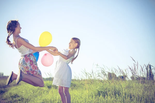 快乐的孩子们白天在田里玩耍 他们在公园的路上走着 手里拿着气球 孩子们玩大自然的乐趣 幸福的概念 — 图库照片