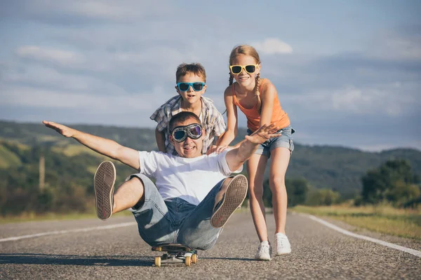 父と子供たちはその日のうちに道路で遊んでいる 屋外で楽しんでいる人 友好的な家族の概念 — ストック写真