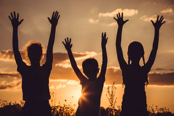 Silhouette Tre Bambini Felici Che Giocano Sul Campo All Ora — Foto Stock