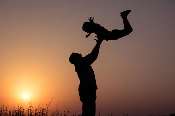 父と息子の日没の時に公園で遊んで フィールド上で楽しんで フレンドリーな家族と夏休みの概念 — ストック写真