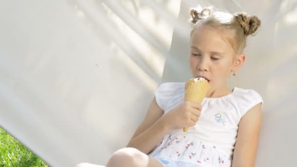 あの日公園のハンモックに寝そべってた女の子 彼女はアイスクリームを食べている 健康食品の概念 — ストック動画