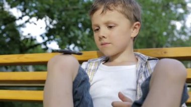 Mutlu küçük çocuk gündüz vakti parkta oynuyor. Spinner 'la oynuyor. Çocuk doğada eğleniyor. Mutluluk kavramı.