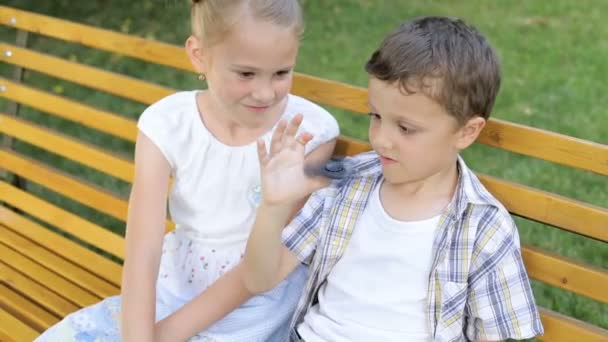 Crianças Felizes Sentadas Banco Durante Dia Estão Brincar Com Spinner — Vídeo de Stock