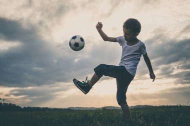 Küçük çocuk futbol topuyla sahada oynuyor. Spor anlayışı.
