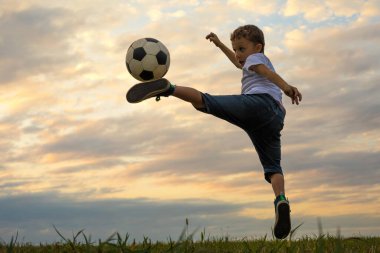 Küçük çocuk futbol topuyla sahada oynuyor. Spor anlayışı.