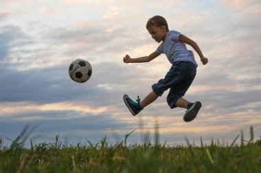 Küçük çocuk futbol topuyla sahada oynuyor. Spor anlayışı.