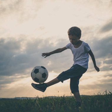 Küçük çocuk futbol topuyla sahada oynuyor. Spor anlayışı.