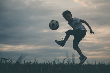 Küçük çocuk futbol topuyla sahada oynuyor. Spor anlayışı.