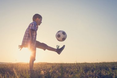 Küçük çocuk futbol topuyla sahada oynuyor. Spor anlayışı.