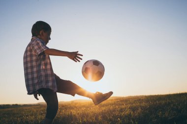 Küçük çocuk futbol topuyla sahada oynuyor. Spor anlayışı.