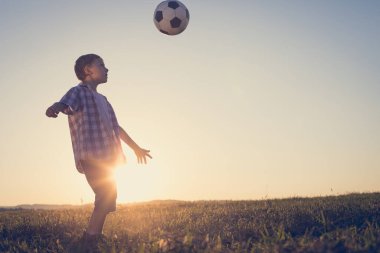 Küçük çocuk futbol topuyla sahada oynuyor. Spor anlayışı.