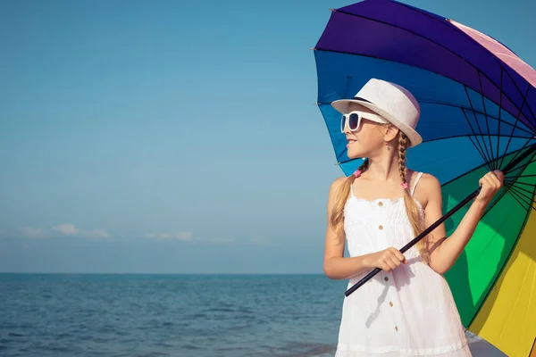 一个快乐的小女孩 白天带着雨伞站在海滩上 孩子们在外面玩得很开心暑假的概念 — 图库照片