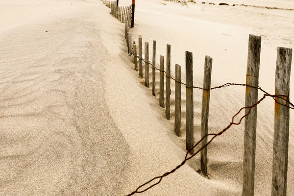 Dunas de areia branca com uma cerca e grama . — Fotografia de Stock