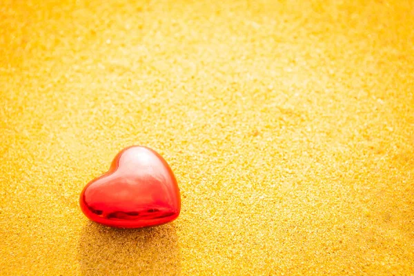 Сладкое сердце на песчаном пляже под закатом и теплый свет — стоковое фото