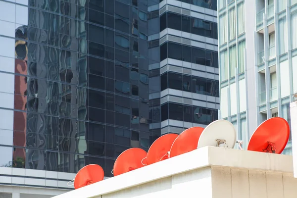 Řadou červených satelitní antény na budově — Stock fotografie