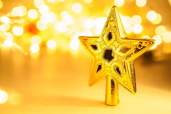 Golden glittering christmas star on Light Bokeh background — Stock Photo, Image