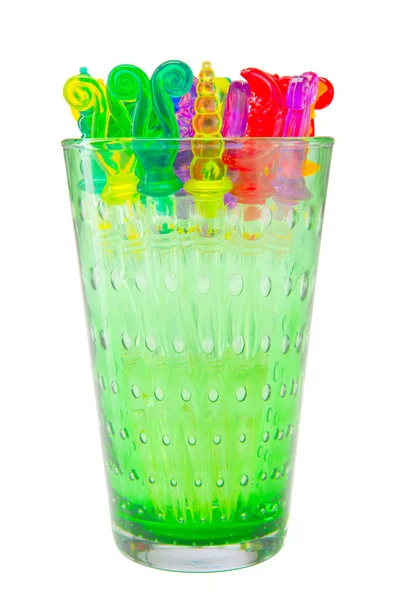 Kolorowe plastikowe kije swizzle w szkło na białym tle wit — Zdjęcie stockowe