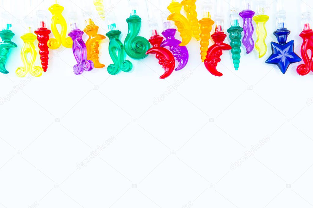 Colorful plastic swizzle sticks on white background with copy sp