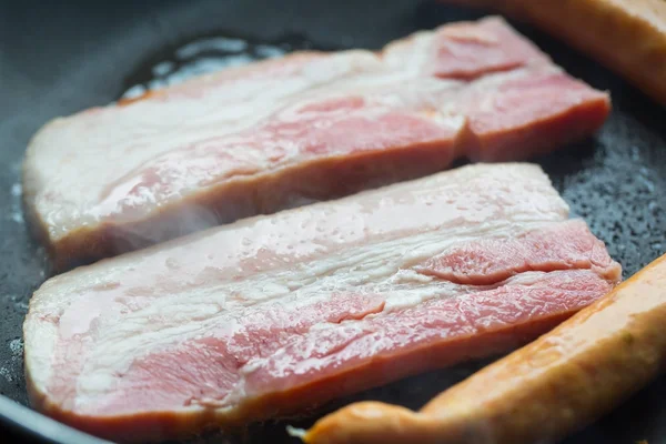 Fried pork and sausage cooking in the pan close up — Stock Image Fried pork and sausage cooking in the pan close up Royalty Free Stock Images