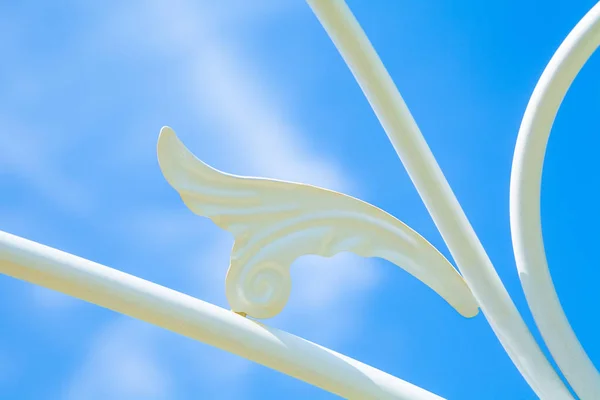 Asa de telhado de arte de ferro forjado branco com céu azul — Fotografia de Stock