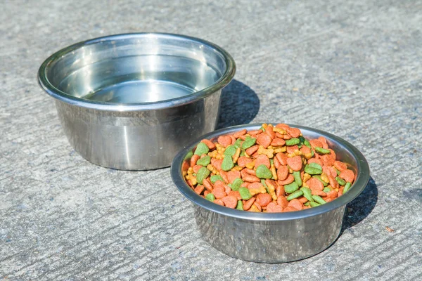 Dry dog food in in the stainless steel bowl and water — Stock Photo, Image