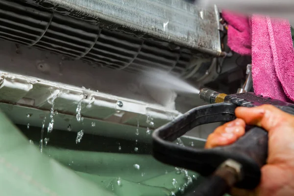 Repairman fixing and cleaning air conditioner unit — Stock Photo, Image