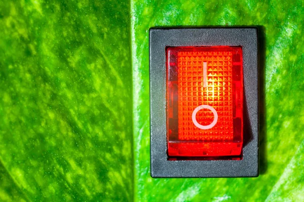 Red power switch on green leaves save World concept friendly ene — Stock Photo, Image