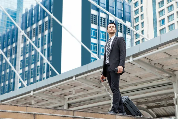 Business man walking at outdoors with luggage in the routine of