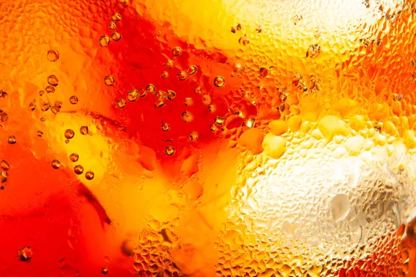 Vista macro de um copo de refrigerante de cola com gelo e gotas de condens — Fotografia de Stock