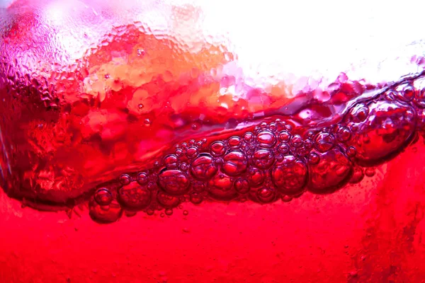 Água com gás vermelho salpicando com bolhas de perto e ponto de orvalho em — Fotografia de Stock