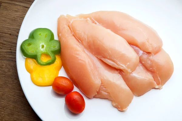 Peitos de frango crus e especiarias na placa branca — Fotografia de Stock