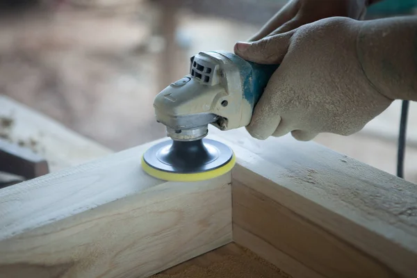 Крупним планом руки тесля, використовуючи силовий інструмент дерев'яний шліфувальний апарат в біді — стокове фото