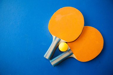 iki Masa Tenisi veya ping pong raketleri ve topları mavi bir tablo
