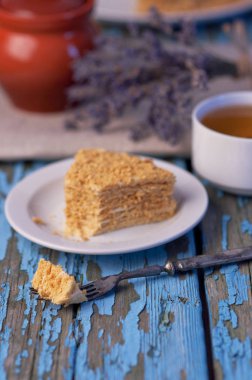 Fincan çay ve bal pasta ahşap mavi zemin üzerine Eflatun