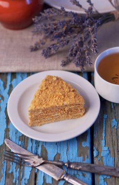 Fincan çay ve bal pasta ahşap mavi zemin üzerine Eflatun