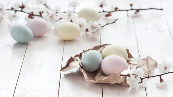 Gefärbte Eier mit Blumen auf weißem Holzgrund. — Stockfoto