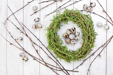 Kukum Beyaz ahşap zemin üzerinde bir yuva Bıldırcın yumurta Paskalya bileşimi.