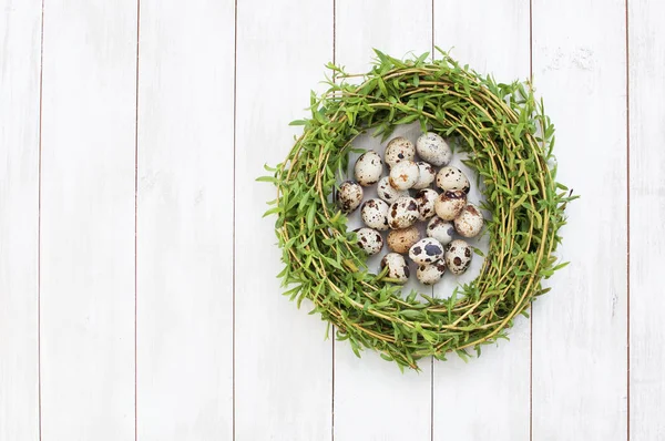 Zusammensetzung von Wachteleiern in einem Nest auf weißem Holzgrund — Stockfoto