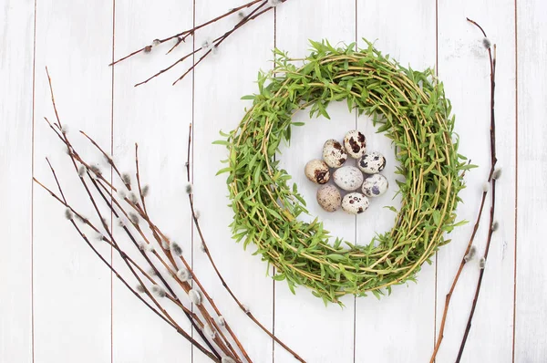 Osterkomposition aus Wachteleiern in einem Nest mit einer Muschi-Weide auf weißem Holzgrund. — Stockfoto