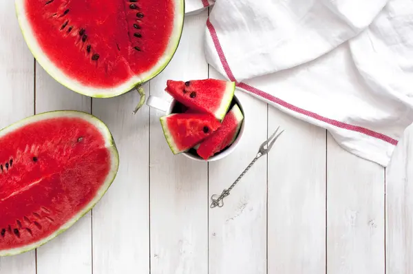 Yarım ve dilim karpuz ışık rustik ahşap arka plan tepesinde görüntülemek.