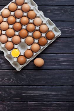 Bir karton kutu içinde tavuk yumurta üstten görünüm kopya alanı bir koyu ahşap tablo.