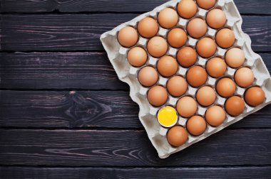 Bir karton kutu içinde tavuk yumurta üstten görünüm kopya alanı bir koyu ahşap tablo.