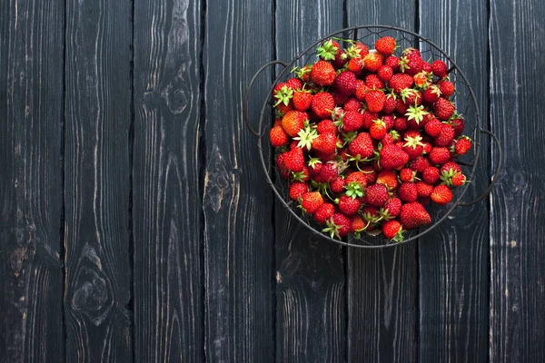 Fresh red strawberry in a bowl on a dark rustic wooden background — Stock Photo, Image