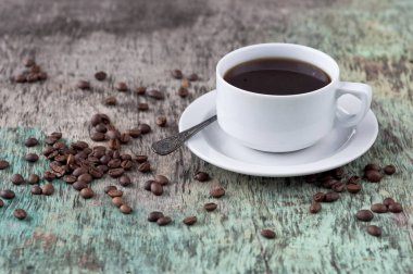 Dağınık tahıl ve gazete ile ahşap bir masa üzerinde siyah kahve bir fincan. Siyah kahve sıcak içecek tahıl gazete ahşap arka plan beyaz fincan Kahvaltı