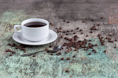 Dağınık tahıl ve gazete ile ahşap bir masa üzerinde siyah kahve bir fincan. Siyah kahve sıcak içecek tahıl gazete ahşap arka plan beyaz fincan Kahvaltı