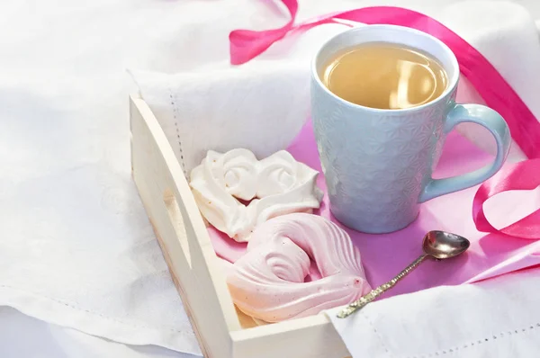 熱いお茶と白い繊維のベッドにハートの形の自家製メレンゲのカップとトレイ 朝のベッドで朝食愛を飲むハーブティー ホット — ストック写真