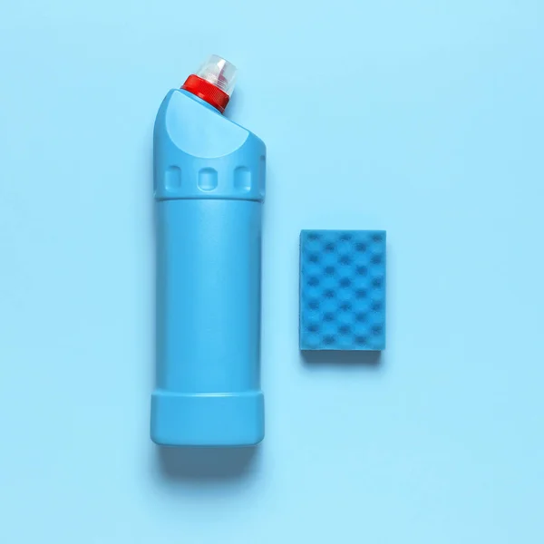 Blauwe plastic fles voor vloeibaar wasmiddel, reinigingsmiddel, bleekmiddel, antibacteriële gel en wasspons op blauwe achtergrond. Huisschoonmaakconcept. Vlak bovenaanzicht. Schoonmaakaccessoires — Stockfoto